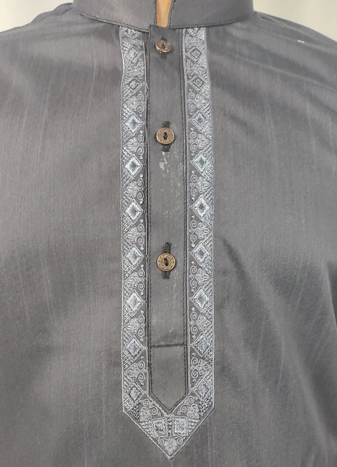 Boy wearing Rai Ahmed graphite grey kurta with embroidery and white trouser.